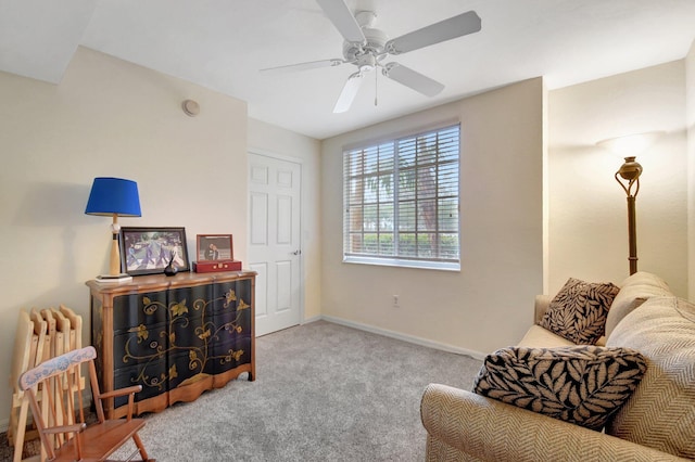 sitting room with ceiling fan, radiator, and light carpet