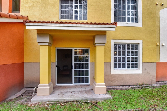 view of exterior entry with a patio