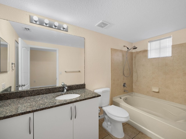 full bathroom featuring vanity, a textured ceiling, tile patterned floors, toilet, and tiled shower / bath