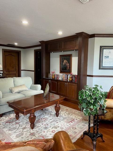 living room featuring hardwood / wood-style floors and crown molding