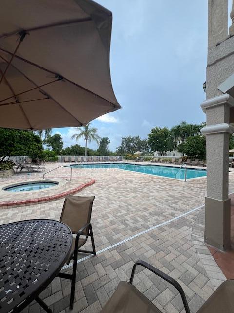 view of pool featuring a community hot tub and a patio area