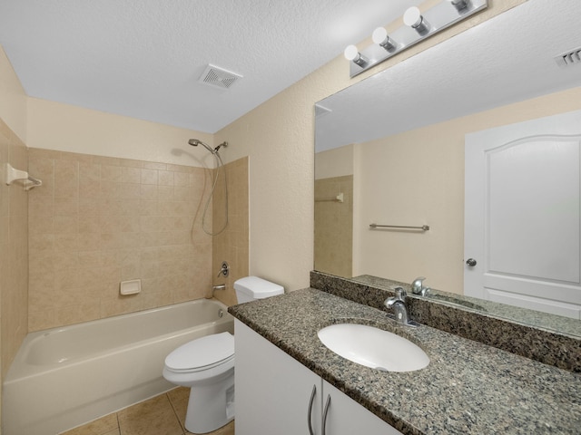 full bathroom with tile patterned flooring, vanity, tiled shower / bath combo, toilet, and a textured ceiling