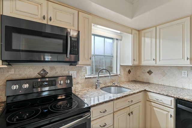 kitchen featuring cream cabinets, electric range oven, sink, and light stone counters