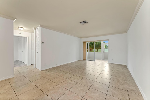 tiled spare room featuring crown molding