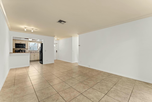 unfurnished living room featuring crown molding, sink, and light tile patterned floors