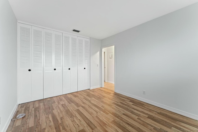 unfurnished bedroom featuring light wood-type flooring and a closet