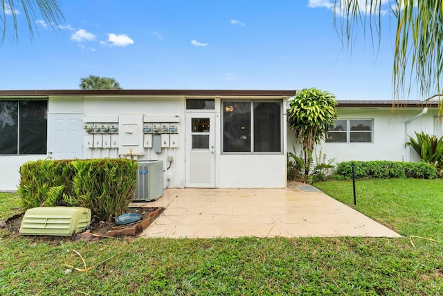 property entrance featuring a patio area, central AC, and a lawn