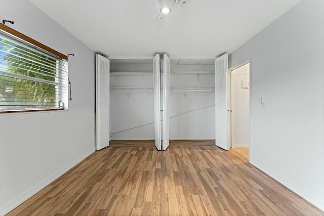 unfurnished bedroom with light hardwood / wood-style flooring and multiple closets