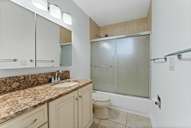 full bathroom featuring vanity, tile patterned floors, toilet, and combined bath / shower with glass door