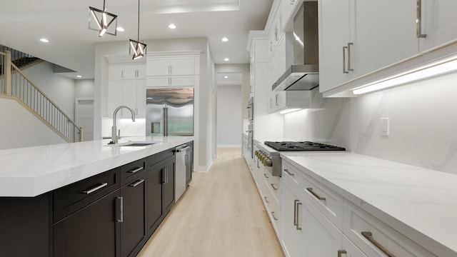 kitchen with white cabinetry, sink, wall chimney exhaust hood, and appliances with stainless steel finishes