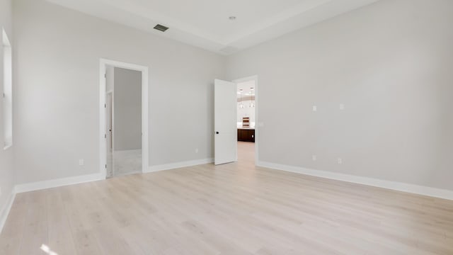 unfurnished bedroom with a spacious closet and light wood-type flooring