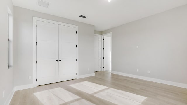 unfurnished bedroom featuring a closet and light hardwood / wood-style flooring