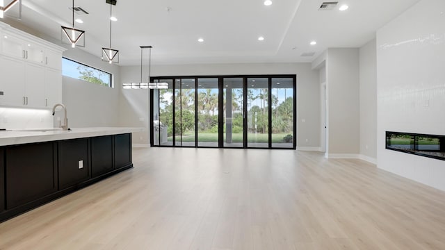 living room featuring sink and light hardwood / wood-style flooring