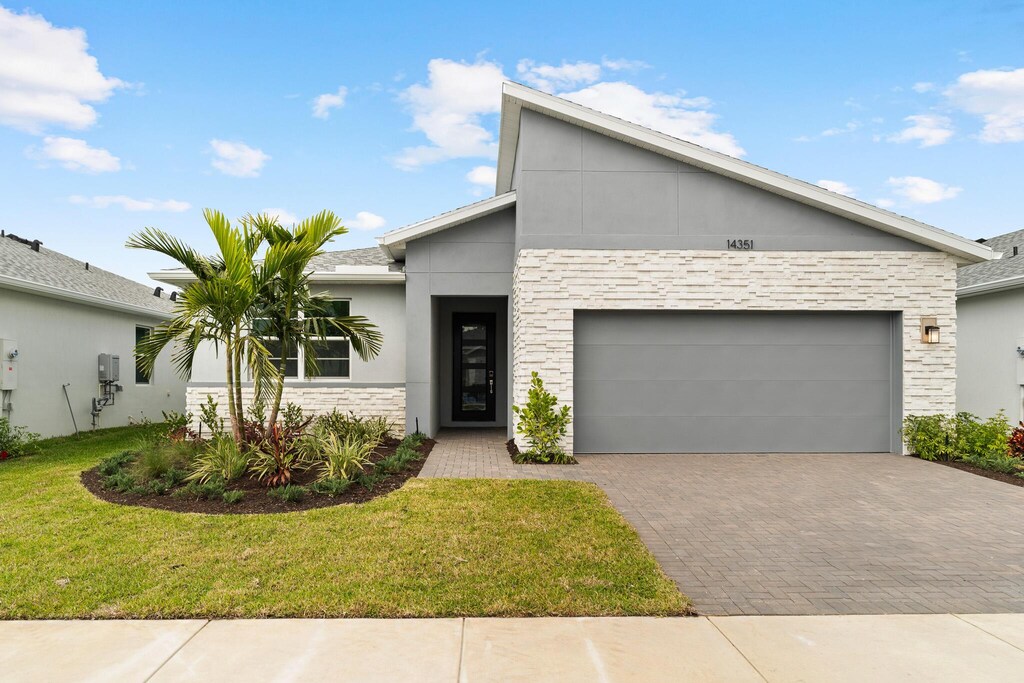 contemporary house featuring a garage and a front yard