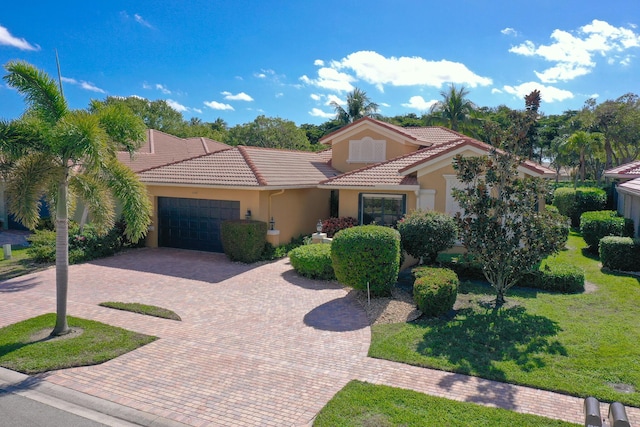 mediterranean / spanish house with a garage and a front lawn