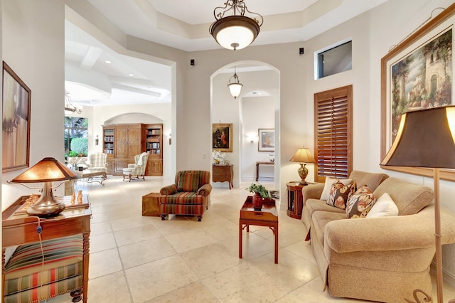 tiled living room with a tray ceiling and a high ceiling