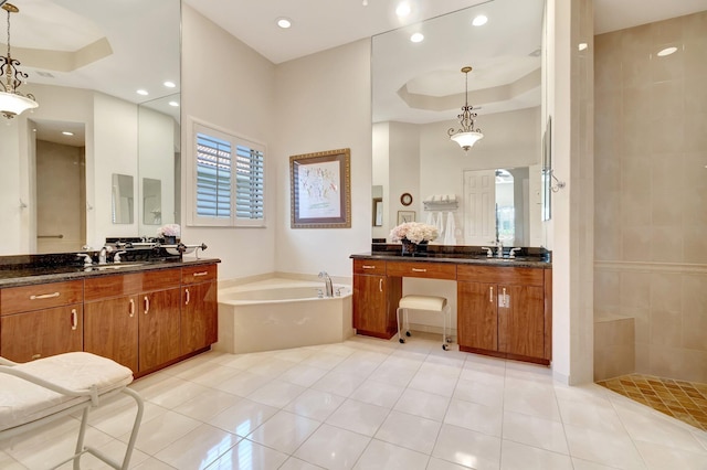 bathroom with tile patterned flooring, shower with separate bathtub, a raised ceiling, and vanity