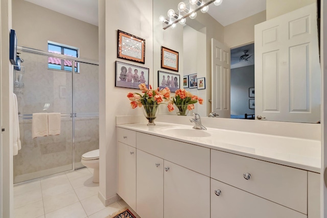 bathroom featuring vanity, toilet, tile patterned flooring, and a shower with door