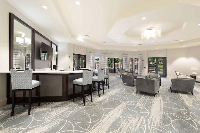 interior space with light carpet, recessed lighting, and a tray ceiling