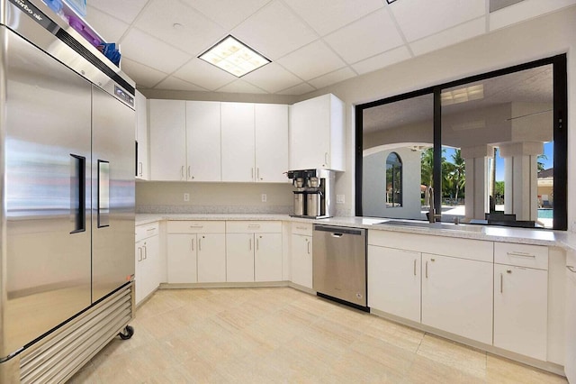 kitchen featuring light countertops, white cabinets, appliances with stainless steel finishes, and a sink