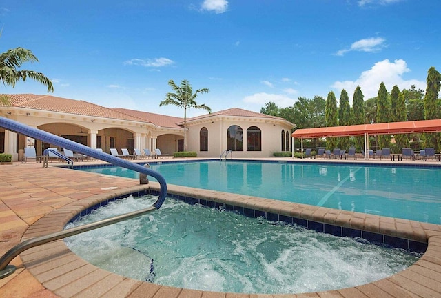 pool with a patio and a community hot tub