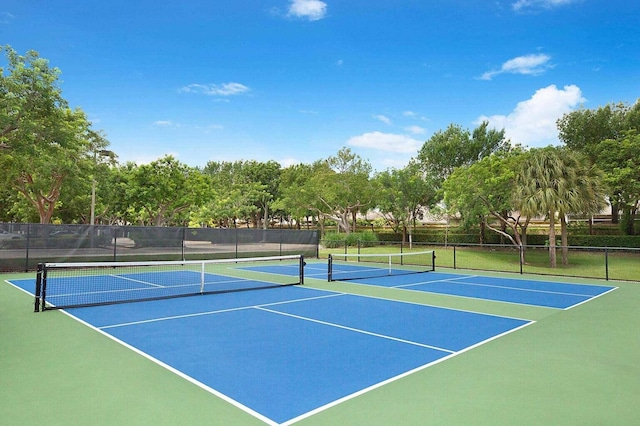 view of tennis court featuring community basketball court and fence