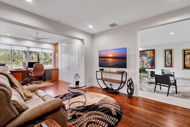 living room featuring hardwood / wood-style floors, built in desk, and ceiling fan