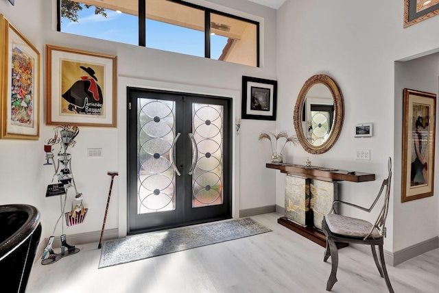 entryway with french doors, plenty of natural light, and light hardwood / wood-style floors