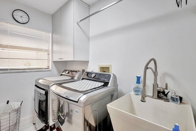 laundry area featuring cabinets, washing machine and dryer, and sink