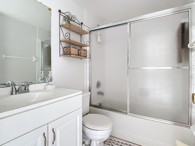 full bathroom with vanity, bath / shower combo with glass door, and toilet