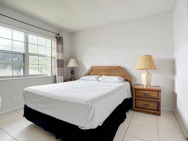 bedroom featuring light tile patterned floors and a textured ceiling