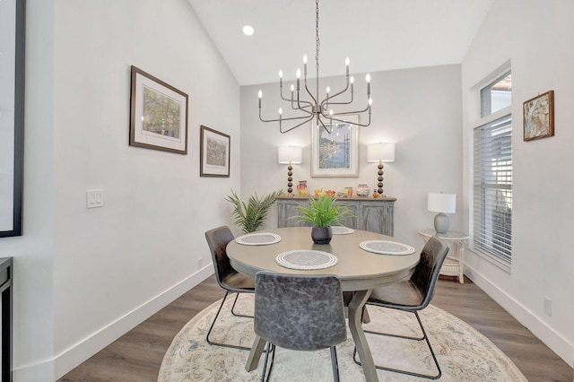 dining space featuring dark hardwood / wood-style floors, a chandelier, and vaulted ceiling