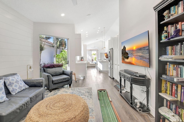 living room with vaulted ceiling and light hardwood / wood-style flooring