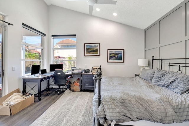 bedroom featuring ceiling fan, dark hardwood / wood-style flooring, high vaulted ceiling, and a textured ceiling