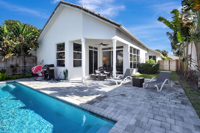 back of property with a fire pit, a patio area, and ceiling fan