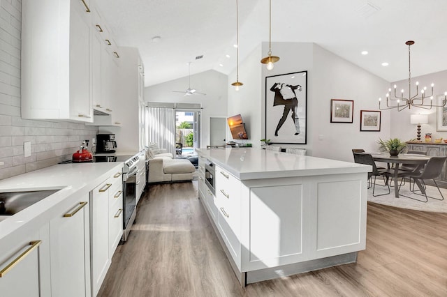 kitchen with tasteful backsplash, white cabinets, and decorative light fixtures