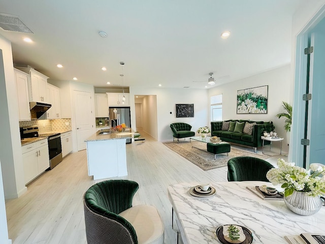 kitchen with visible vents, appliances with stainless steel finishes, a sink, white cabinetry, and backsplash