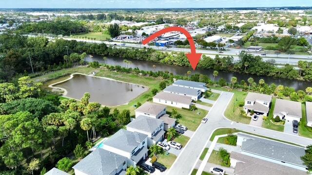 birds eye view of property with a water view and a residential view