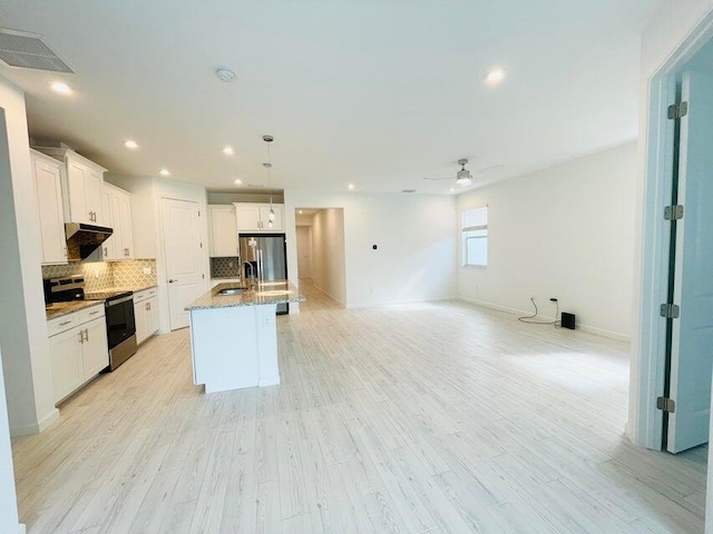 kitchen with tasteful backsplash, visible vents, under cabinet range hood, stainless steel appliances, and a sink