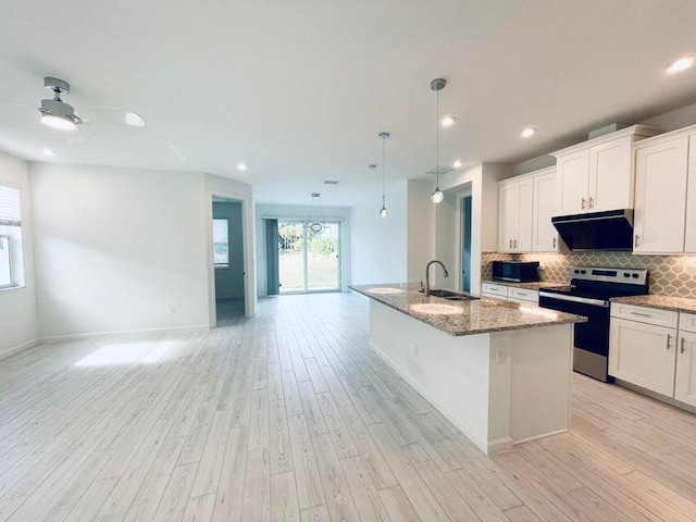 kitchen featuring a sink, tasteful backsplash, open floor plan, light wood-style floors, and stainless steel electric range oven