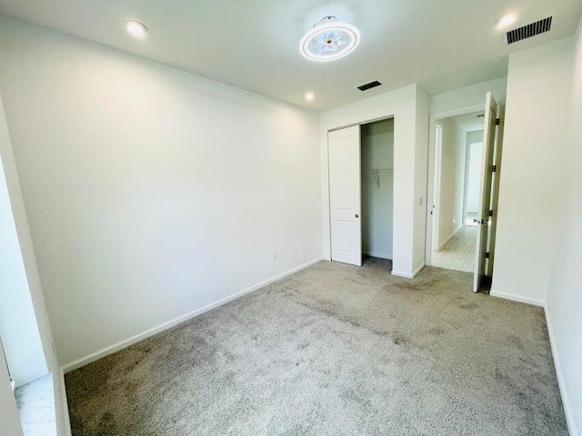 unfurnished bedroom featuring visible vents, baseboards, a closet, and carpet flooring