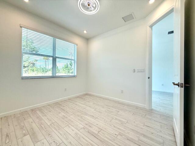 empty room with a wealth of natural light and light wood-type flooring