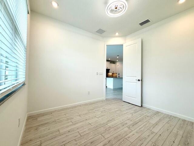 spare room with visible vents, recessed lighting, light wood-type flooring, and baseboards