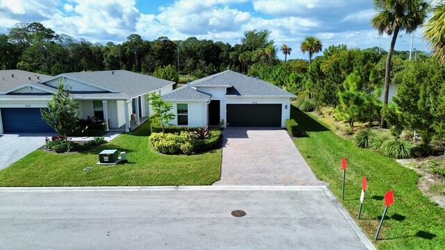 6716 Pointe Of Woods Dr, West Palm Beach, FL 33413 - ranch-style house with an attached garage, a front lawn, and decorative driveway