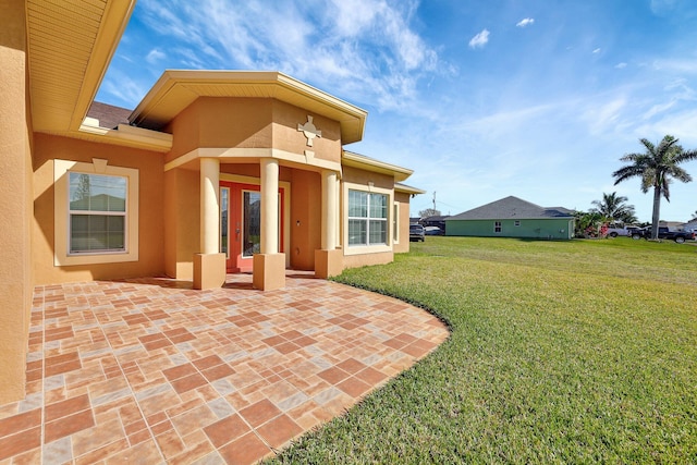 back of property with a patio and a lawn