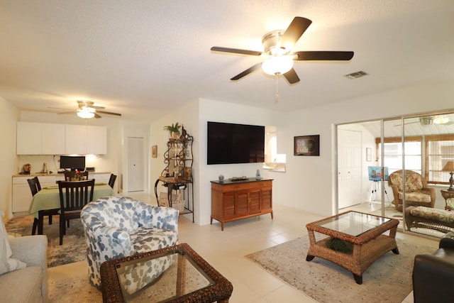 tiled living room featuring a textured ceiling and ceiling fan