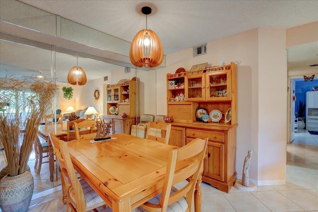 dining space with a textured ceiling and light tile patterned flooring