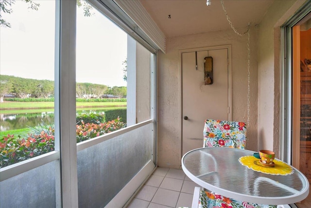 sunroom / solarium with a water view and a healthy amount of sunlight