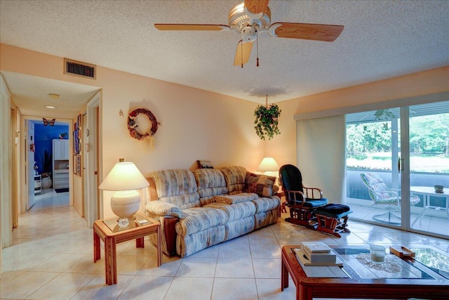 living room featuring light tile patterned floors, a textured ceiling, and ceiling fan