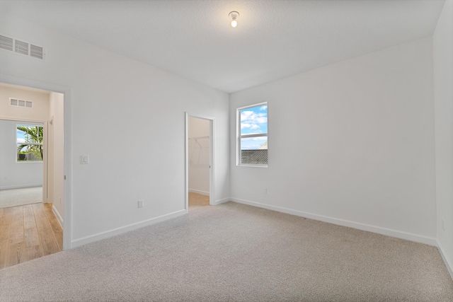 carpeted empty room with a healthy amount of sunlight